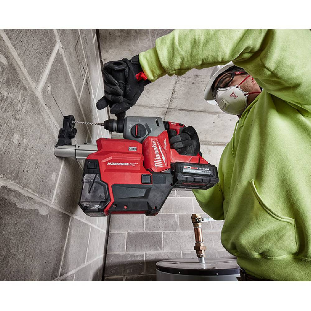 Milwaukee 2912-DE M18 FUEL Cordless Brushless HAMMERVAC 1in Dedicated Dust Extractor (Tool Only) showing in use attached to drill extracting dust while drilling into a concrete wall (Drill sold separately)