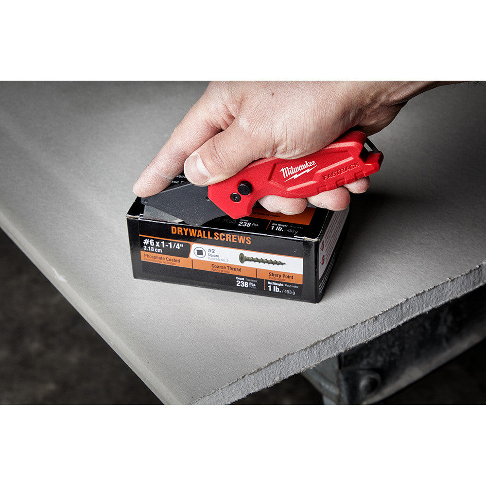 Milwaukee 48-22-1500 FASTBACK Compact Folding Utility Knife showing in use cutting open box of nails