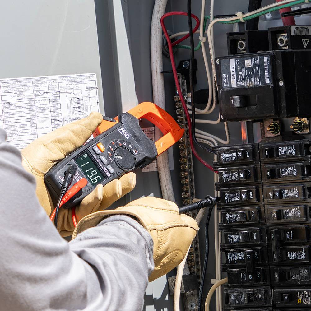 Klein Tools CL710 600 Amp AC/DC Auto-Ranging Digital Pro Clamp Meter showing in use measuring electrical elements with leads