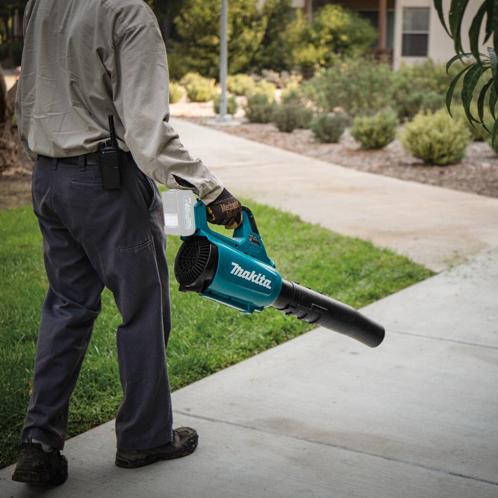 Makita UB001GZ 40V MAX XGT Cordless Brushless Turbo Blower (Tool Only) showing in use blowing debris off of a side walk