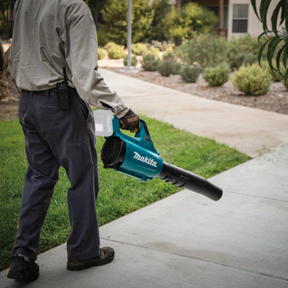 Makita UB001GZ 40V MAX XGT Cordless Brushless Turbo Blower (Tool Only) showing in use blowing debris off of a side walk