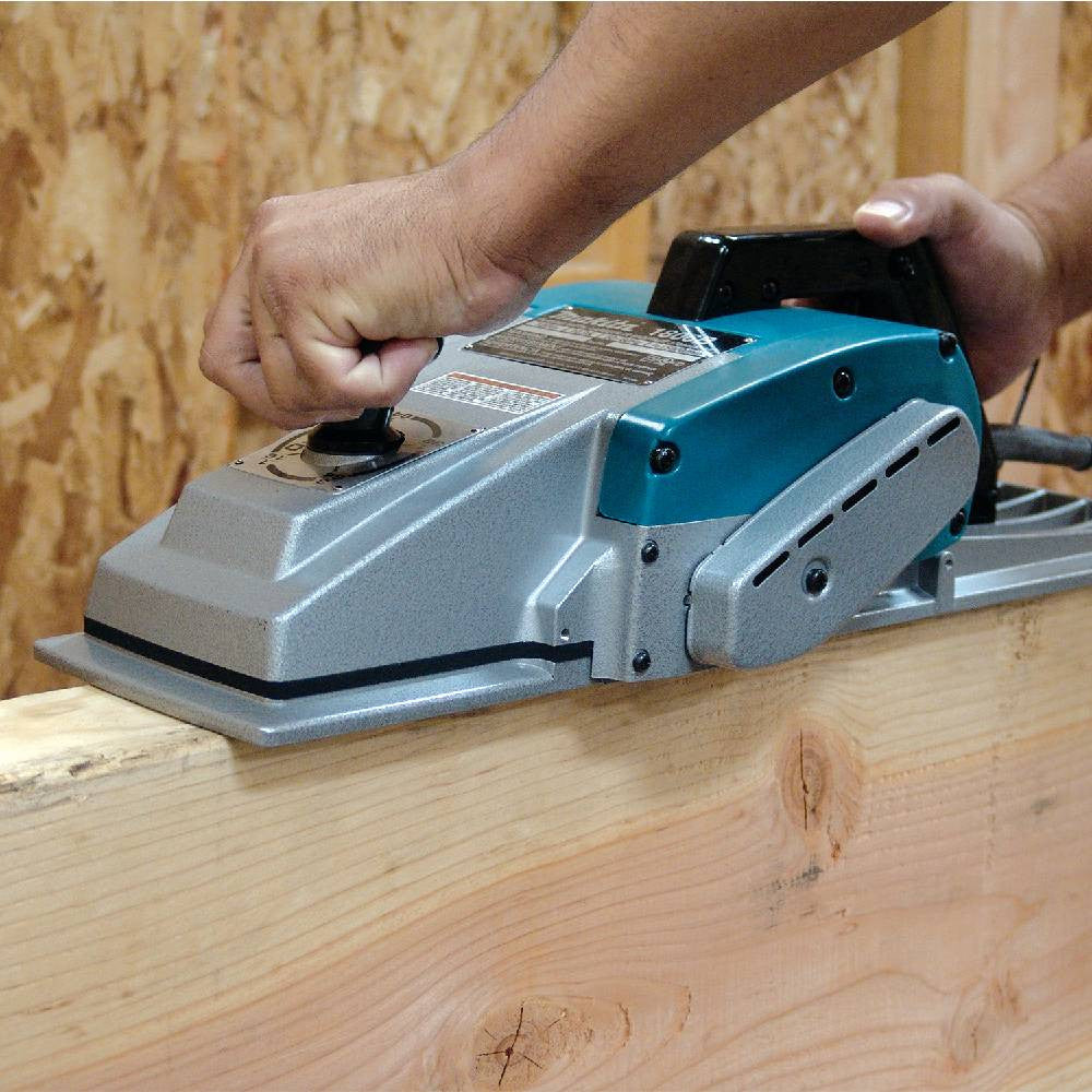 Makita 1806B 10.9 Amp 6-3/4in Planer showing in use planning edge of a wood beam