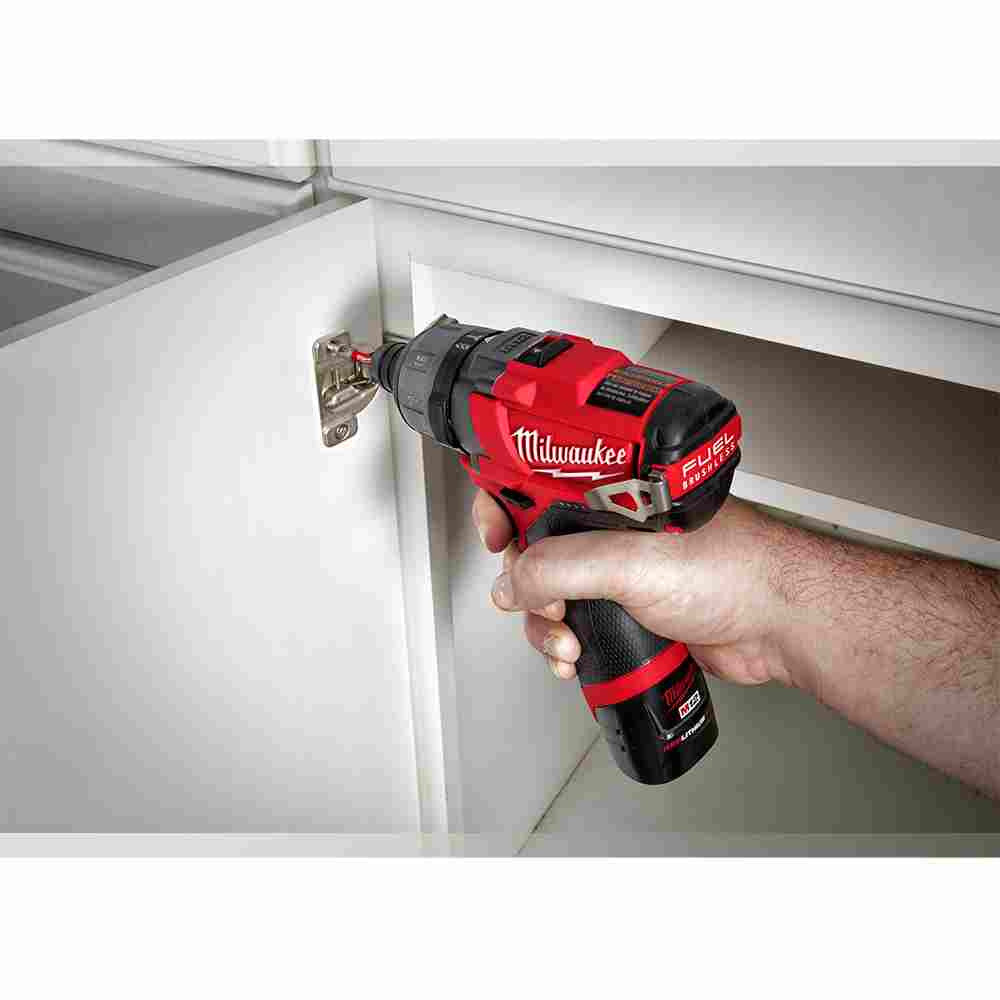 Milwaukee 2402-22 M12 FUEL Cordless Brushless 1/4 inch Hex 2-Speed Screwdriver Kit showing fastening hinge to cabinet door