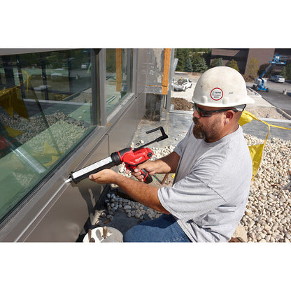 Milwaukee 2441-20 M12 Cordless 10oz. Caulk and Adhesive Gun (Tool Only) showing in use sealing windows on side of the wall