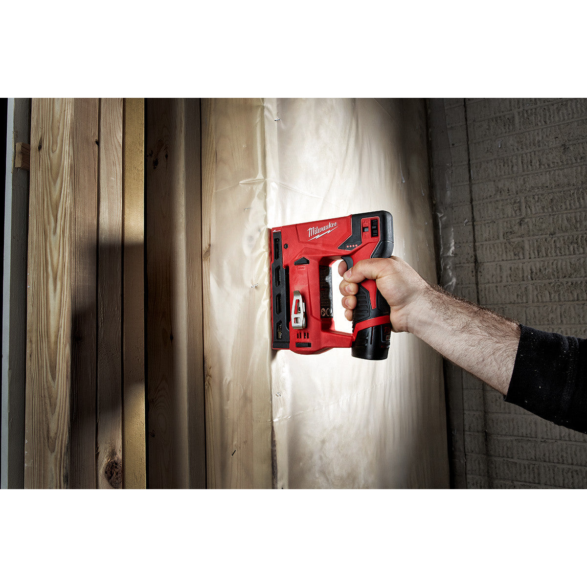 Milwaukee 2447-20 M12 3/8-inch Crown Stapler stapling insulation on a framing stud (battery sold separately)