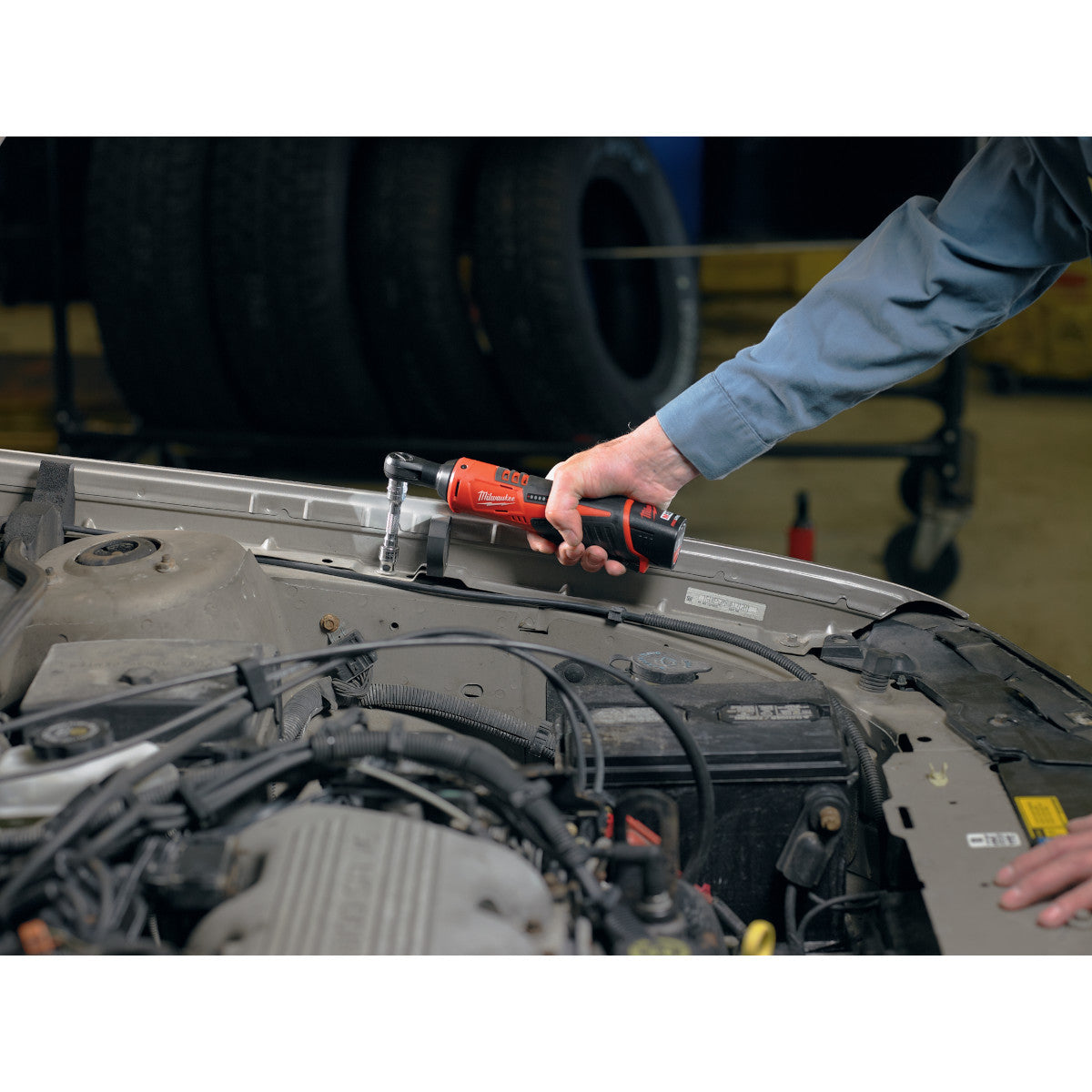 Milwaukee 2457-20 M12 Cordless 3/8 inch Ratchet tightening a bolt on a car (battery sold separately)