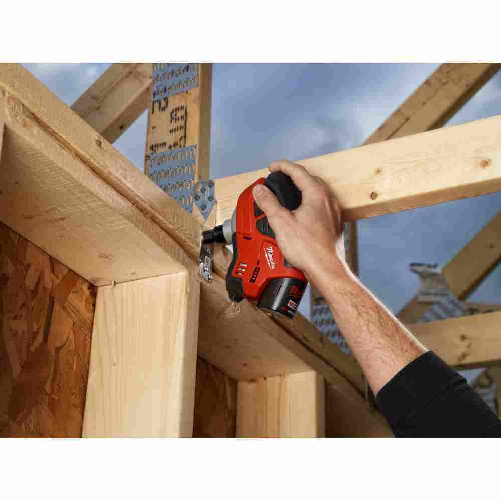 Milwaukee 2458-20 M12 Cordless Palm Nailer (Tool Only) showing in use driving nail into joist hanger
