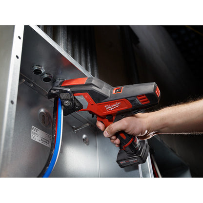 Milwaukee 2472-21XC M12 Cordless 600 MCM Cable Cutter Kit showing in use cutting cable inside a breaker panel
