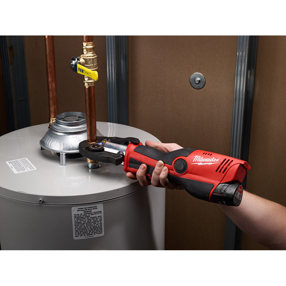 Milwaukee 2473-22 M12 FORCE LOGIC Cordless Press Tool Kit with Jaws Kit showing in use crimping copper pipe coming off a hot water tank