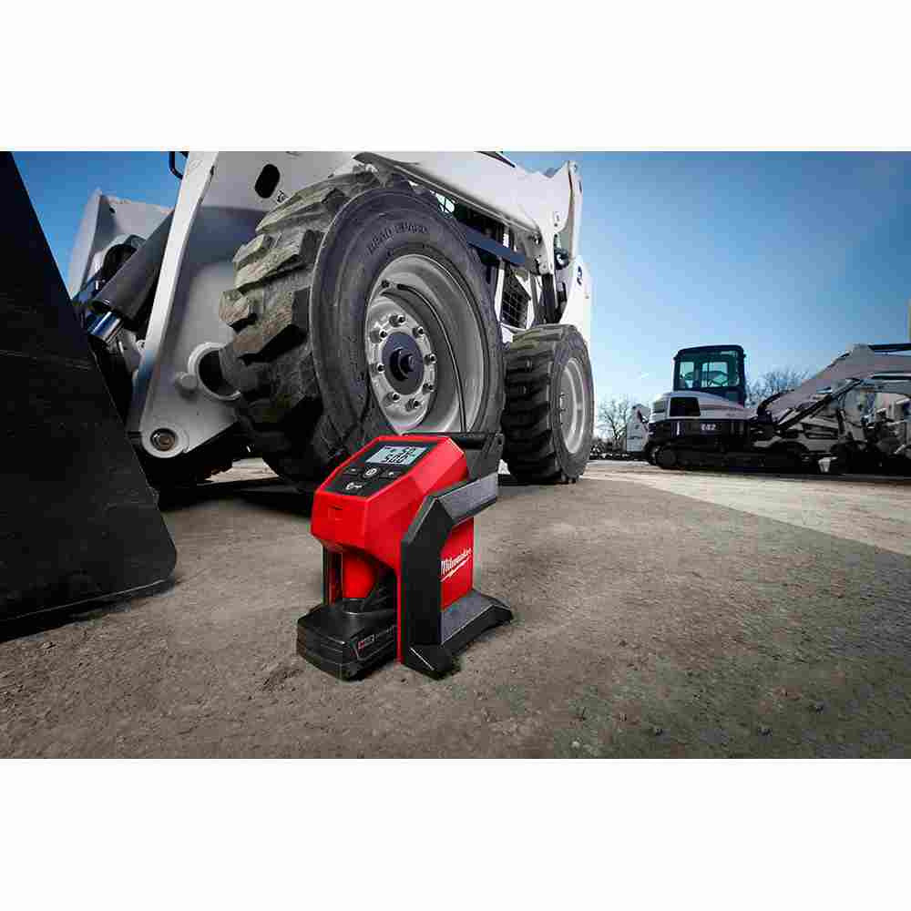 Milwaukee 2475-21XC M12 Cordless Compact Air Inflator Kit showing on jobsite next the machine inflating tires