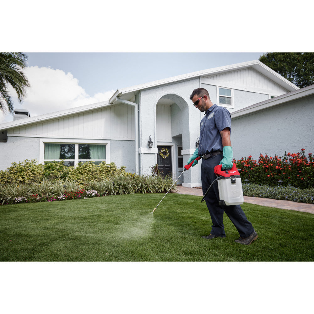 Milwaukee 2528-21G2 M12 Cordless 2 Gallon Handheld Sprayer Kit showing in use spraying lawn with water