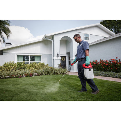 Milwaukee 2528-21G2 M12 Cordless 2 Gallon Handheld Sprayer Kit showing in use spraying lawn with water
