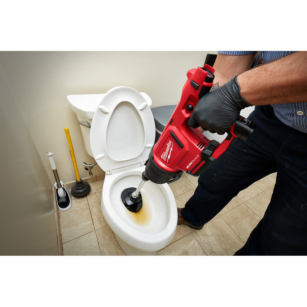 Milwaukee 2572B-21 M12 AIRSNAKE Cordless Drain Cleaning Air Gun Kit showing in use clearing a toilet