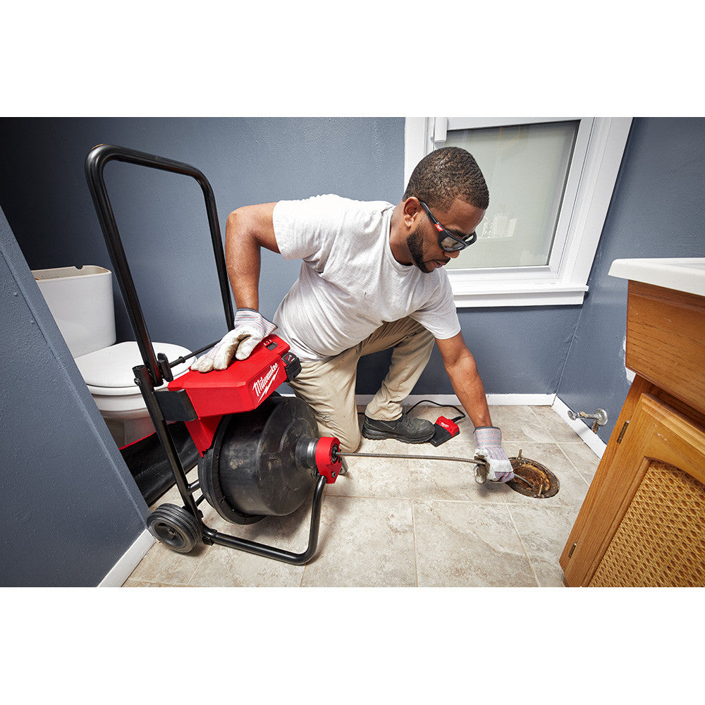 Milwaukee 2817A-21 18V DRUM MACHINE with 3/8in CABLE showing in use clearing out a toilet drainage pipe