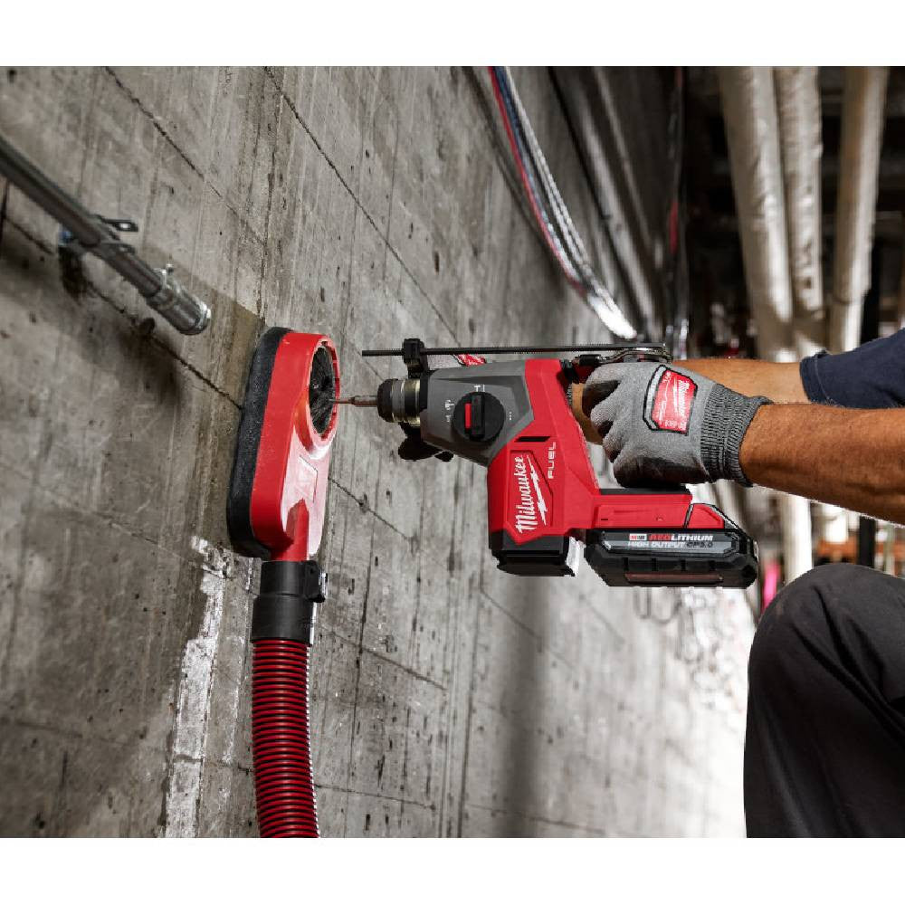 Milwaukee 2908-20 M18 FUEL Cordless Brushless 5/8 inch SDS Plus Rotary Hammer (Tool Only) showing in use drilling into concrete wall with dust extracting attachment (Battery and attachment sold separately)