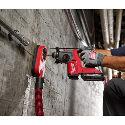 Milwaukee 2908-20 M18 FUEL Cordless Brushless 5/8 inch SDS Plus Rotary Hammer (Tool Only) showing in use drilling into concrete wall with dust extracting attachment (Battery and attachment sold separately)