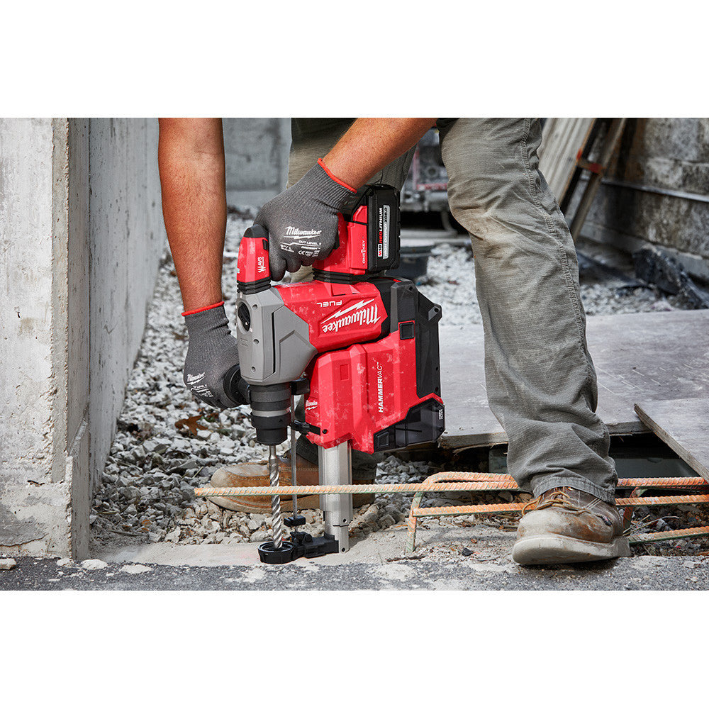 Milwaukee 2915-22DE M18 FUEL Cordless 1-1/8 inch SDS Plus Rotary Hammer with HAMMERVAC Dedicated Dust Extractor Kit showing in use drilling vertically downward into concrete floor
