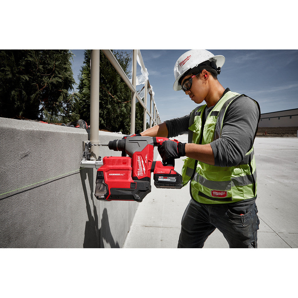 Milwaukee 2915-22DE M18 FUEL Cordless 1-1/8 inch SDS Plus Rotary Hammer with HAMMERVAC Dedicated Dust Extractor Kit showing in use drilling horizontally into concrete wall to mount a railing