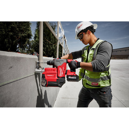 Milwaukee 2915-22DE M18 FUEL Cordless 1-1/8 inch SDS Plus Rotary Hammer with HAMMERVAC Dedicated Dust Extractor Kit showing in use drilling horizontally into concrete wall to mount a railing