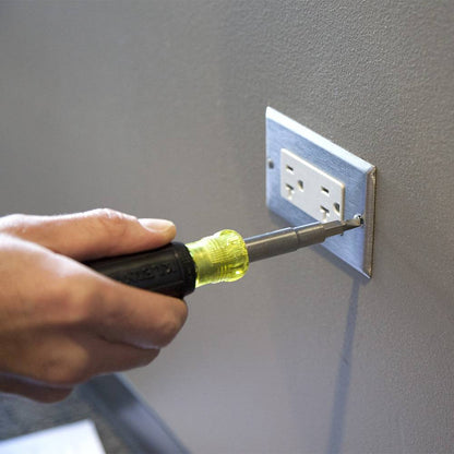 Klein Tools 32500 11-in-1 Multi-Bit Magnetic Screwdriver / Nut Driver showing in use fastening outlet plate cover to the wall