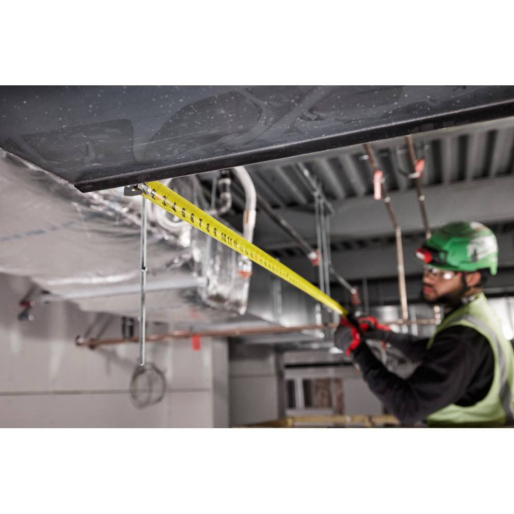 Milwaukee 48-22-1225M 25' Wide Blade Magnetic Tape Measure showing in use measuring out metal ducting