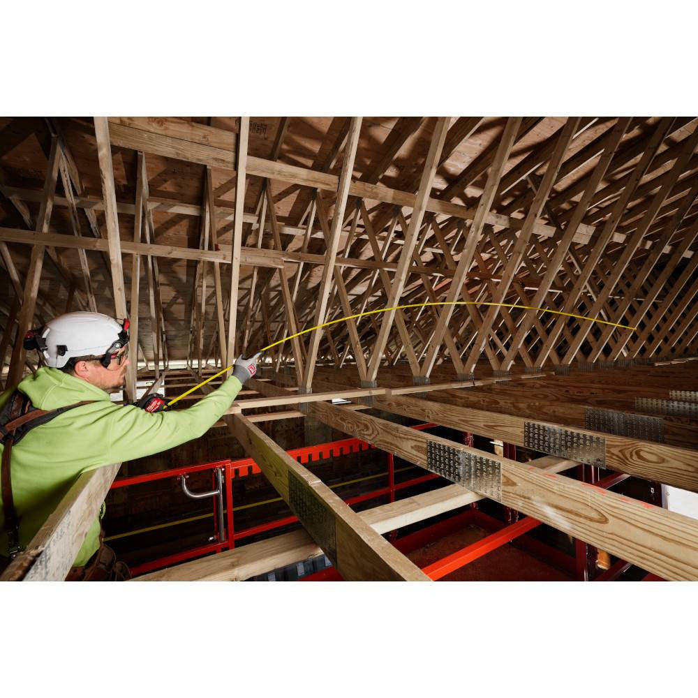 Milwaukee 48-22-1225 25' Wide Blade Tape Measure showing in use measuring the distance between roof rafters