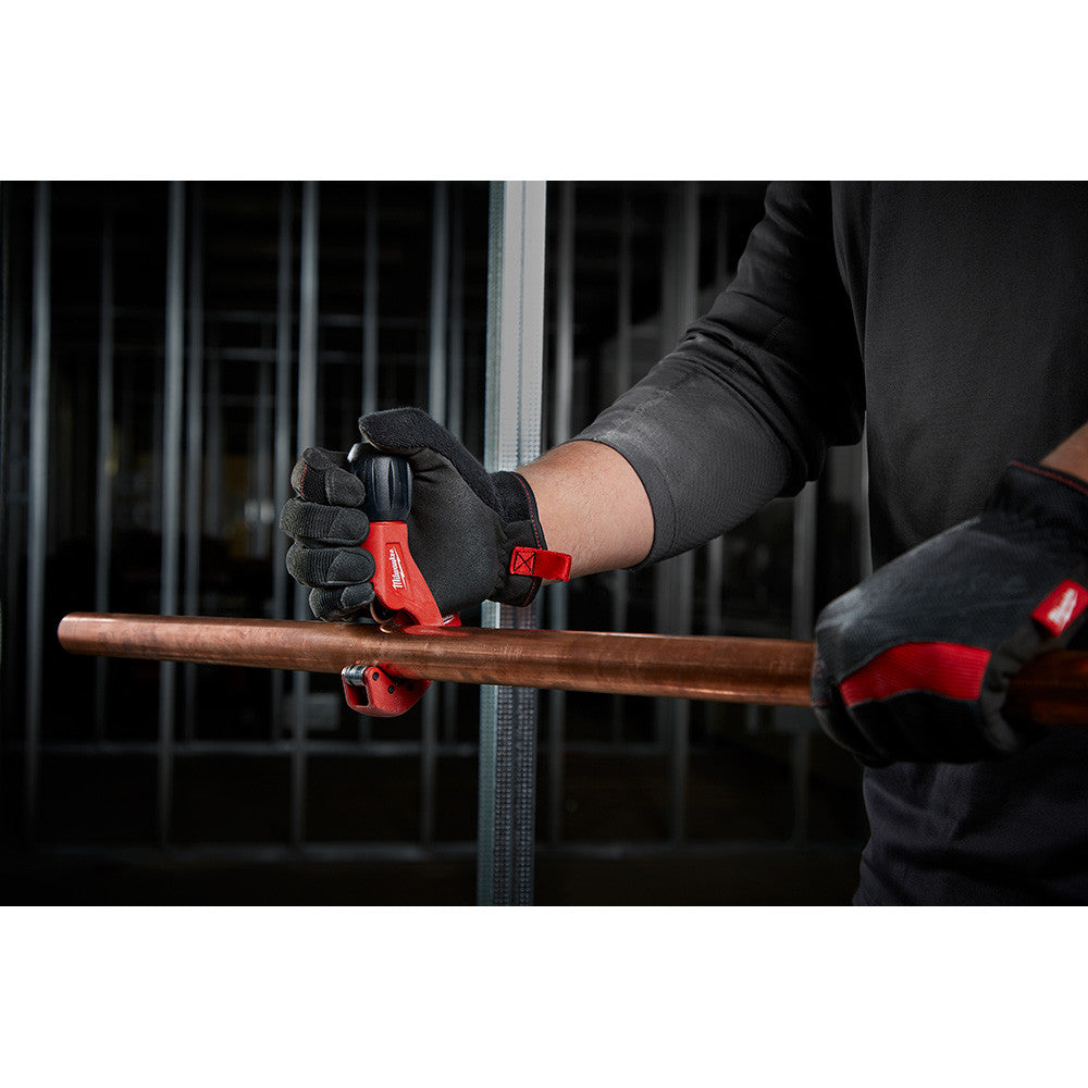 Milwaukee 48-22-4259 1 inch Constant Swing Copper Tubing Cutter showing in use cutting pipe while being held
