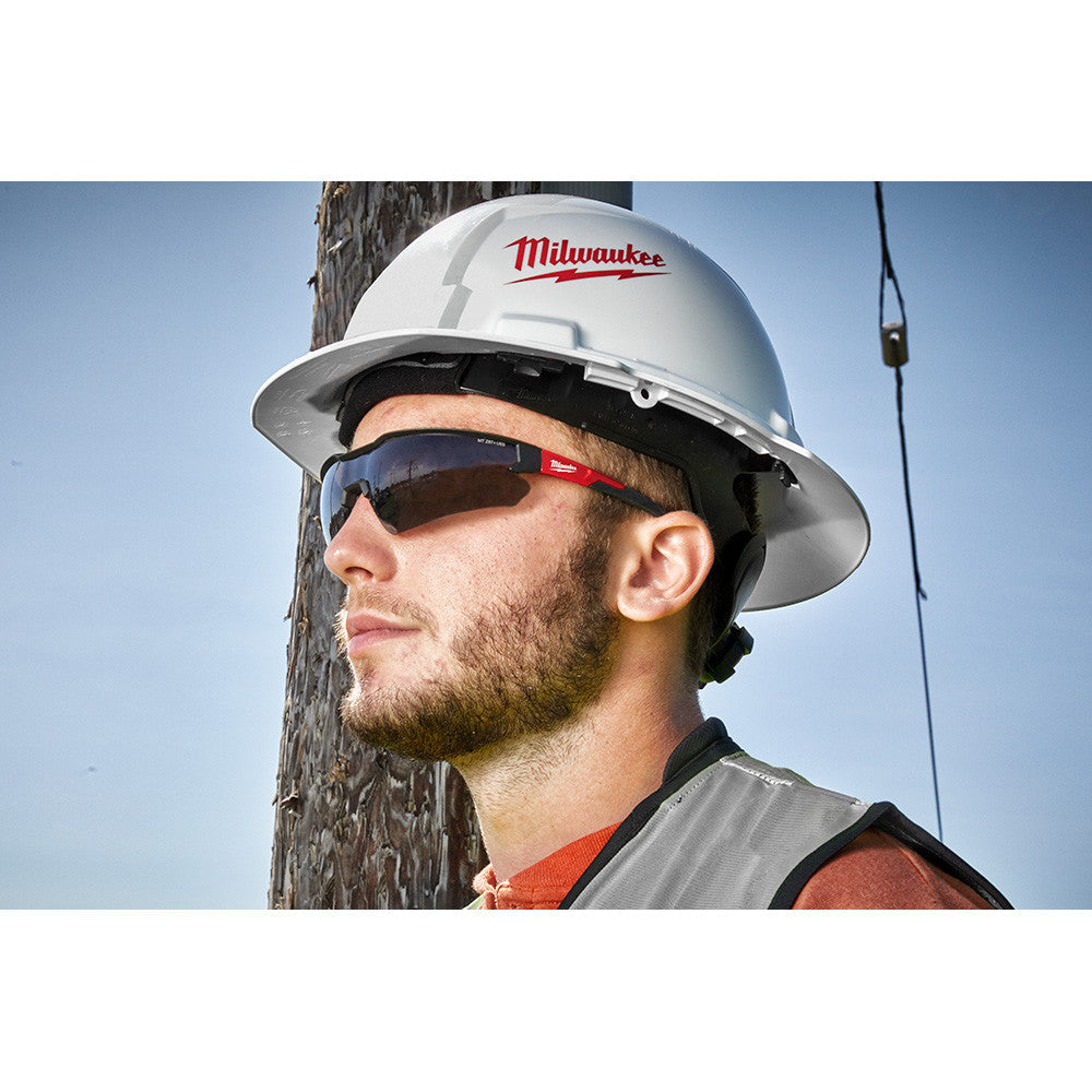Milwaukee 48-73-2015 Anti-Scratch Tinted Safety Glasses showing in use with contractor wearing them injunction with a hard hat