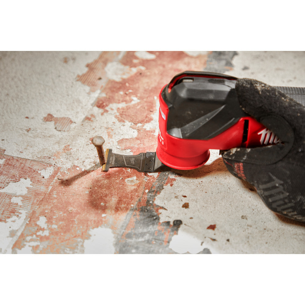 Milwaukee 49-25-1503 OPEN-LOK 1-3/8-inch Universal Fit Titanium Enhanced Carbide Teeth Metal Cutting Multi-Tool Oscillating Blades - 3pk showing in use cutting nail sticking out of a sub floor