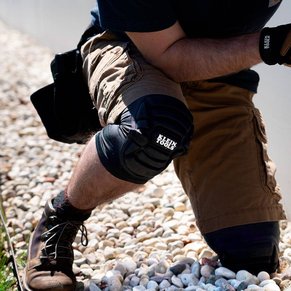 Klein Tools 60592 Lightweight Knee Pad Sleeves - L/XL showing being worn and kneeling on gravel while working