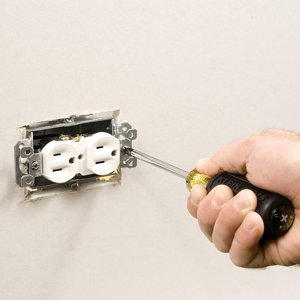 Klein Tools 85445 5pc Slotted, Phillips and Square Screwdriver Set showing in use fastening outlet into junction box on a wall
