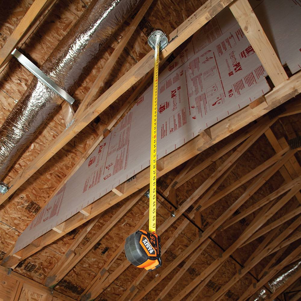 Klein Tools 9375 25-feet/7.5-meter Magnetic Double-Hook Tape Measure showing in use measuring height of junction box