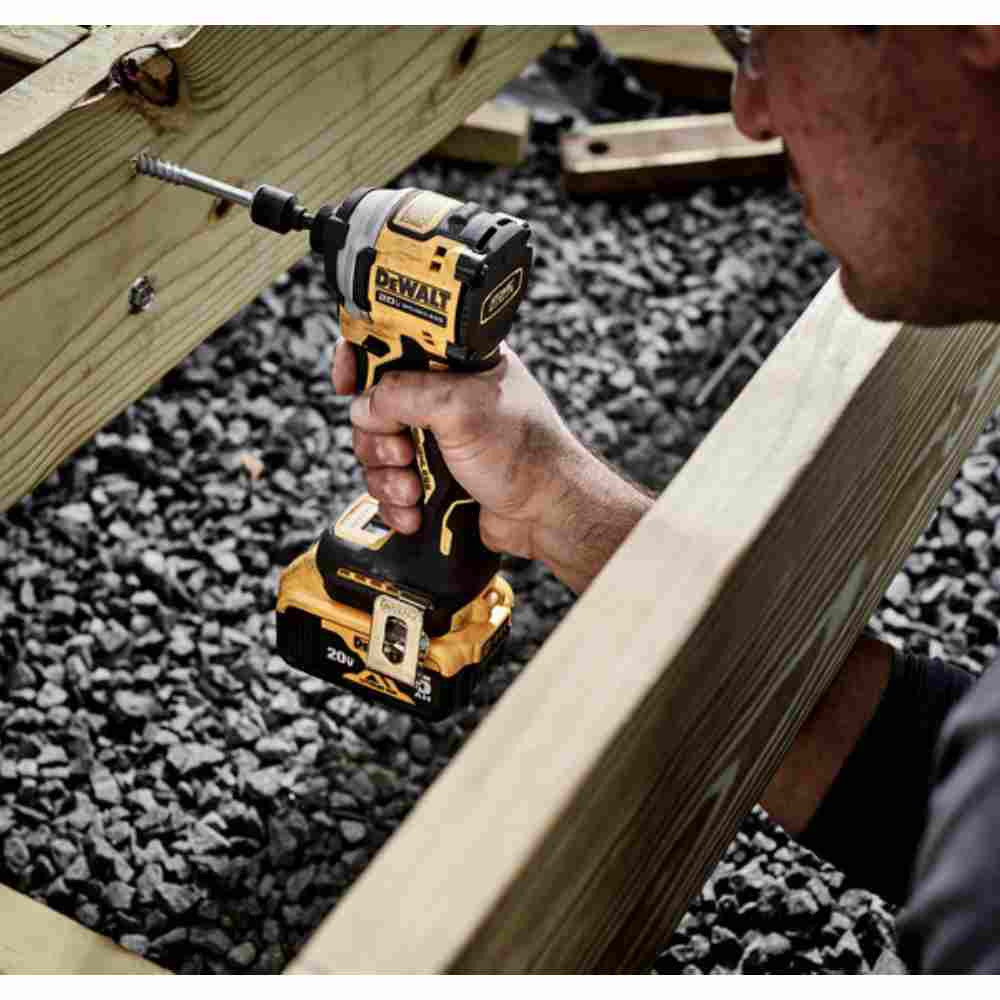DeWalt DCF850P1 ATOMIC 20V MAX Cordless Brushless 3-Speed 1/4 inch Impact Driver Kit showing in use driving bolt into wood floor joist for deck