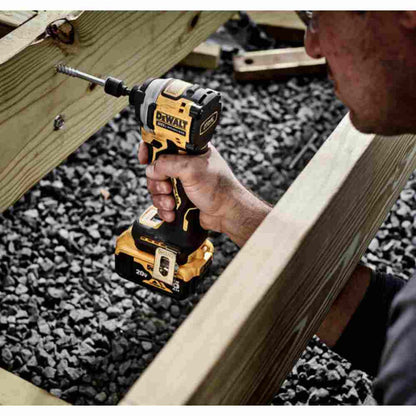 DeWalt DCF850P1 ATOMIC 20V MAX Cordless Brushless 3-Speed 1/4 inch Impact Driver Kit showing in use driving bolt into wood floor joist for deck