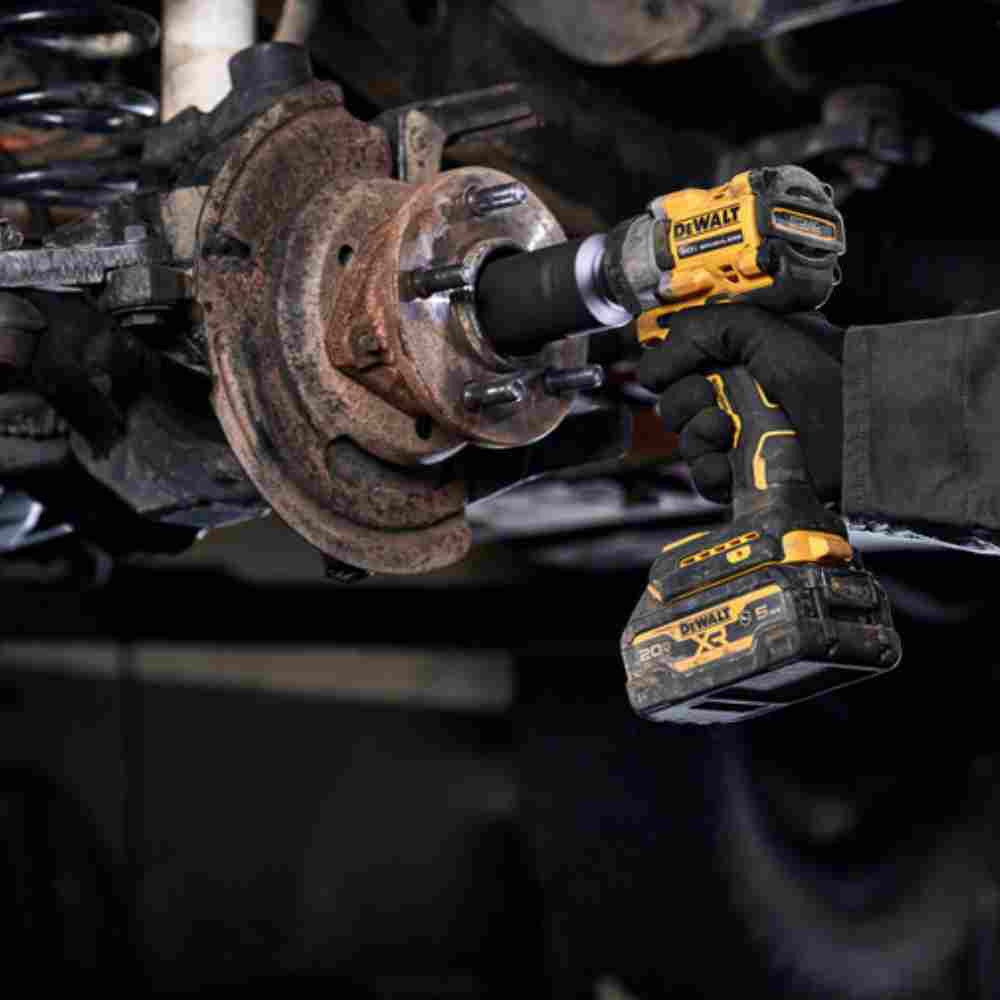 DeWalt DCF922B ATOMIC 20V MAX Cordless Brushless 1/2 inch Impact Wrench with Detent Pin Anvil (Tool Only) showing in use tightening axil bolt on a vehicle