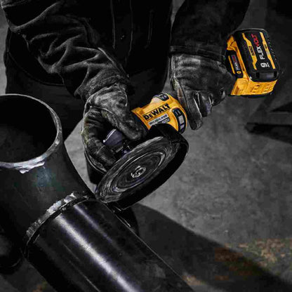 DeWalt DCG440B FLEXVOLT 60V MAX 7 inch Cordless Brushless Grinder With Kickback Brake (Tool Only) showing in use cutting black iron piping