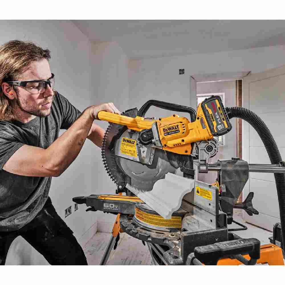 DeWalt DCS781X1 60V MAX 12 inch Cordless Brushless Double Bevel Sliding Miter Saw Kit showing in use cutting crown molding with miter and bevel while saw s mounted on the stand