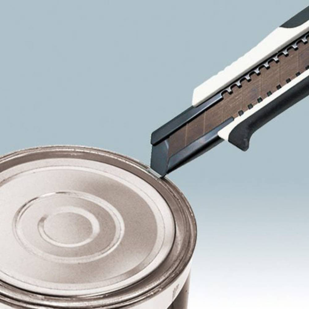 Tajima DFC560N Premium Cutter Series 560 Utility Knife with Auto-Lock showing in use prying open a paint can with the pry tip