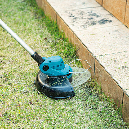 Makita DUR193Z 18V LXT Cordless 10-1/4 inch Line Trimmer (Tool Only) showing in use cutting grass allow wooden boarder