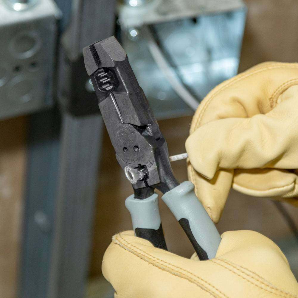 Klein Tools J2159CRTP Hybrid Pliers with Crimper, Fish Tape Puller and Wire Stripper showing in use crimping a terminal end to wire