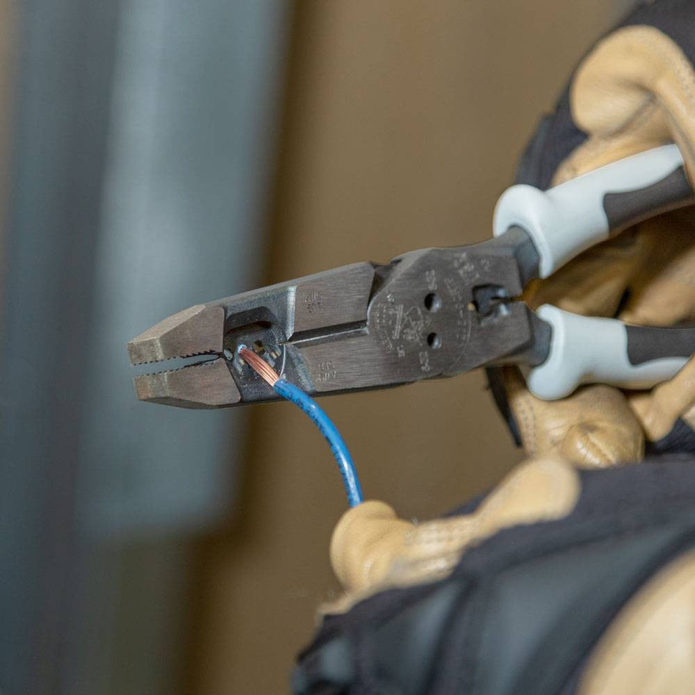 Klein Tools J2159CRTP Hybrid Pliers with Crimper, Fish Tape Puller and Wire Stripper showing in use stripping wire