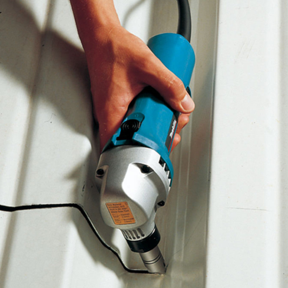 Makita JN1601 5 Amp 16-Gauge Metal Nibbler showing in use cutting metal material in a tight confined area