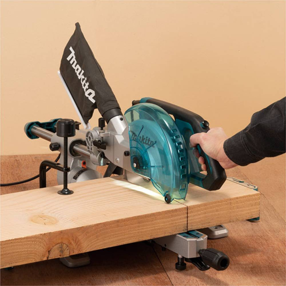 Makita LS0816F 8-1/2in 10.5 Amp Sliding Compound Mitre Saw with LED Cut Line showing in use cutting wood plank