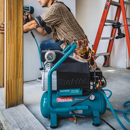 Makita MAC700 12.4 Amp 2 HP Big Bore 2.6 Gallon Air Compressor showing in use suppling air to an air nailer