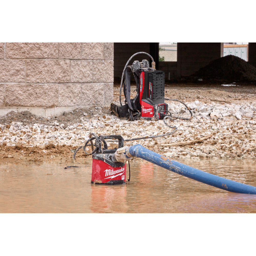 Milwaukee MXF211-1XC MX FUEL 1HP 2in Submersible Pump Kit showing in use pumping water out of a open pit of water