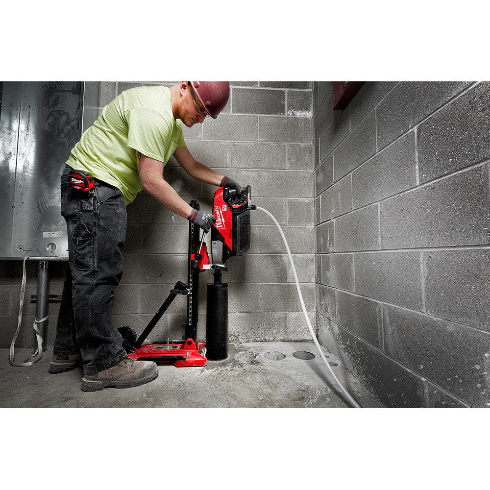 Milwaukee MXF301-2CXS MX FUEL Cordless Brushless Handheld Core Drill Kit with Stand showing in use coring a hole in concrete floor while mounted to the portable stand