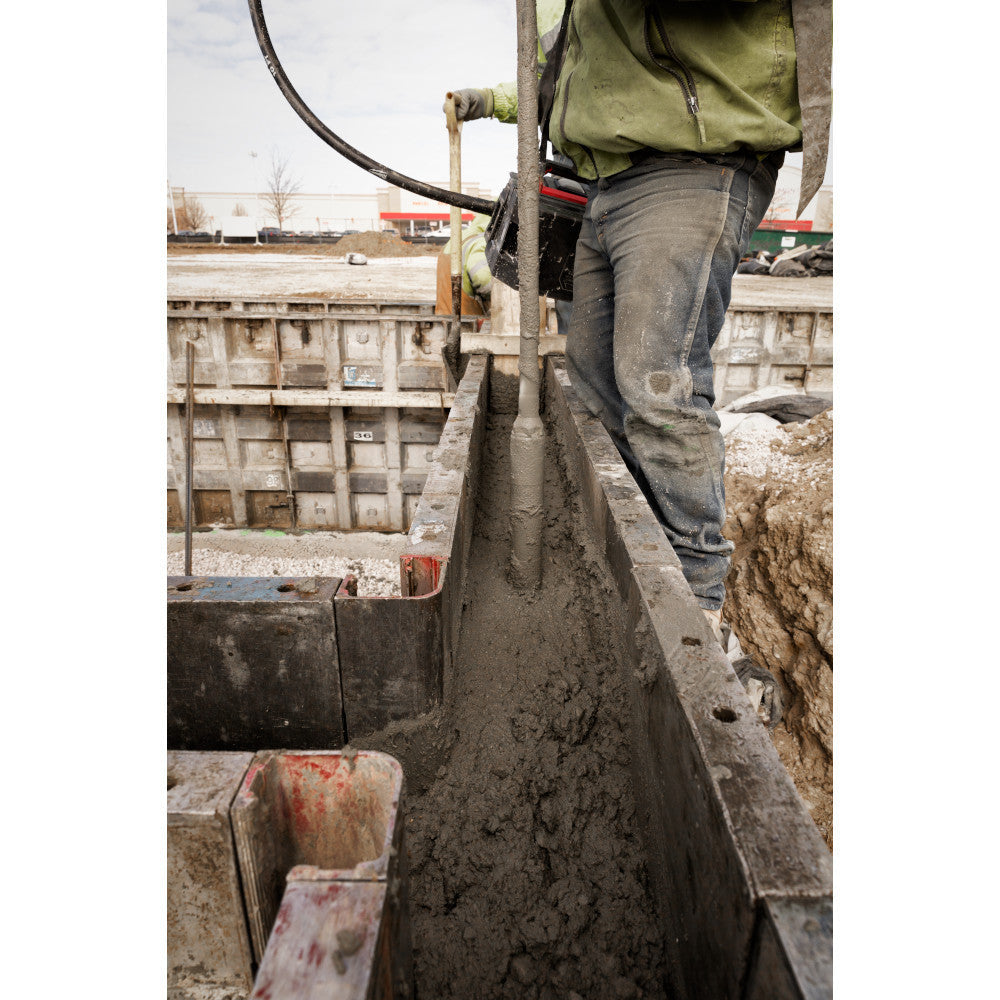 Milwaukee MXF370-2XC MX FUEL Cordless Brushless Concrete Vibrator Kit showing in use vibrating concrete for foundation with in form work