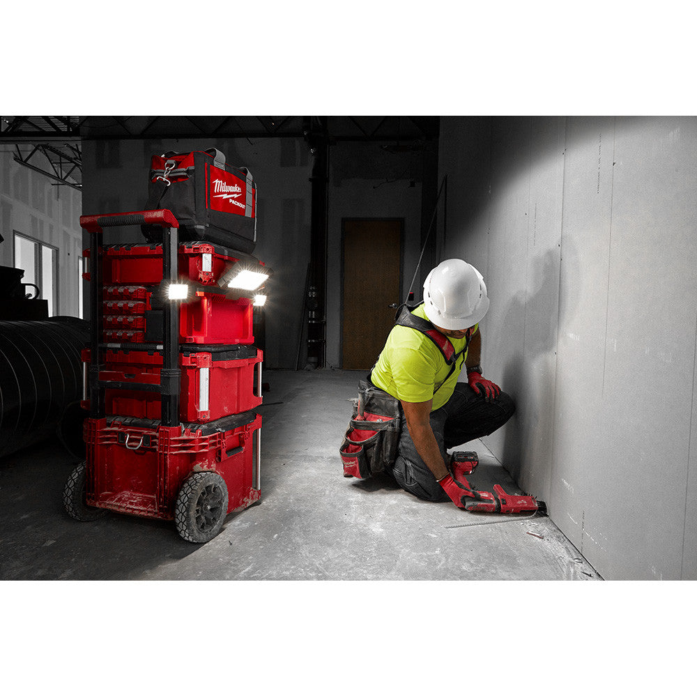 Milwaukee 2357-20 M18 PACKOUT Light/Charger illuminating workspace on a PACKOUT storage stack (sold separately)