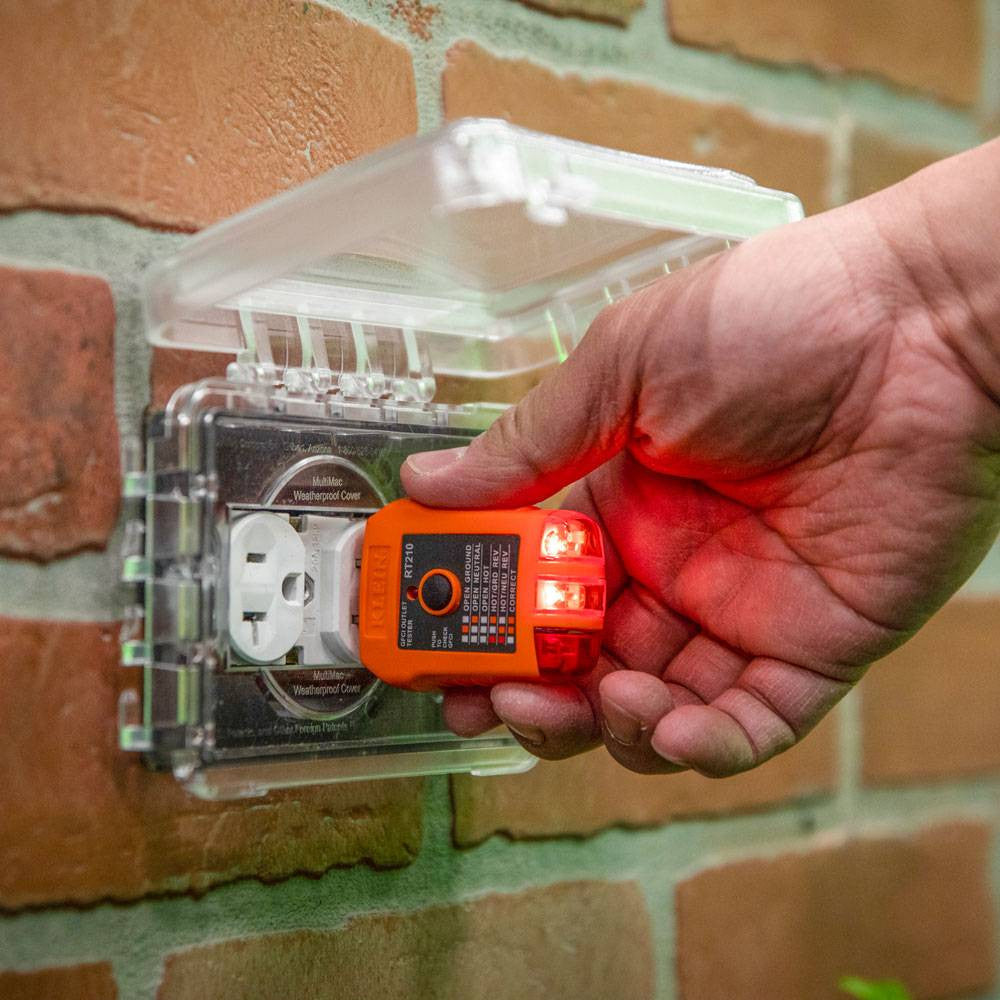 Klein Tools NCVT1XTKIT Non-Contact Voltage and GFCI Receptacle Premium Test Kit showing in use testing a exterior outlet