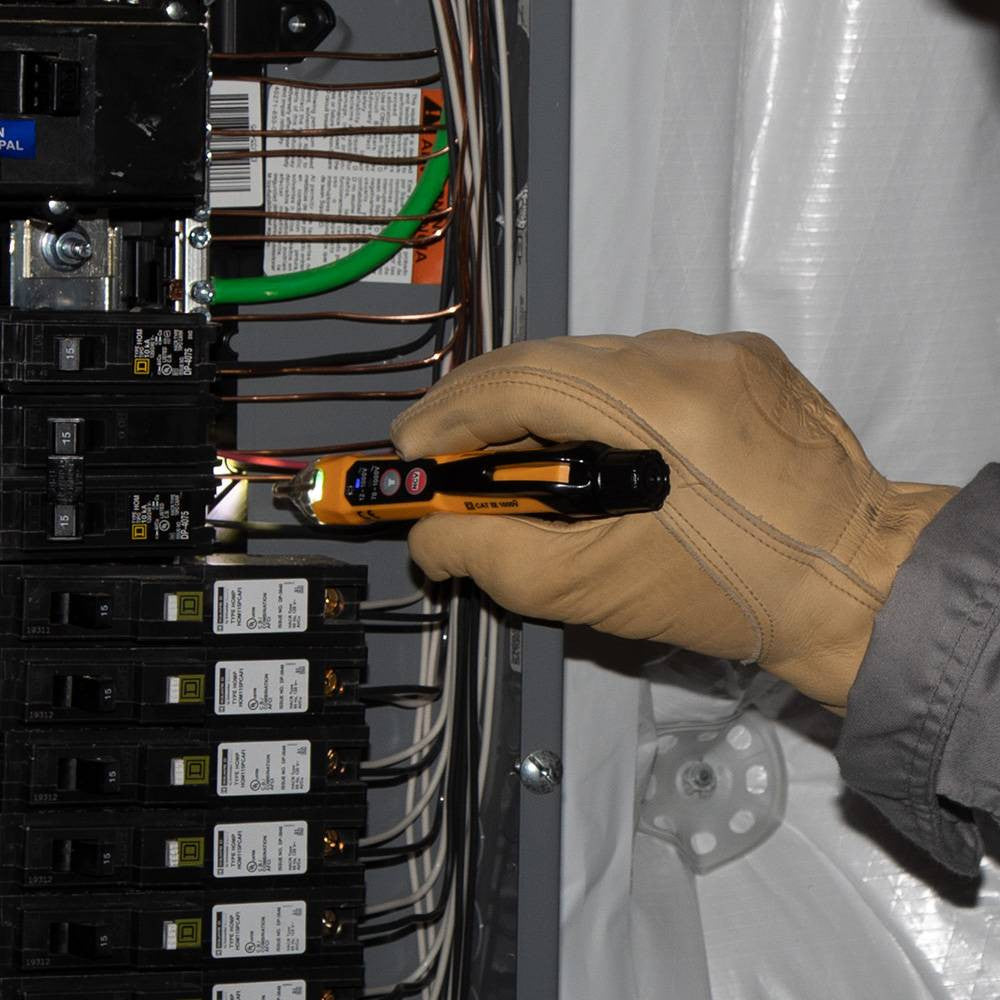 Klein Tools NCVT3P 12V to 1000V AC Dual Range Non-Contact Voltage Tester with Flashlight showing in use checking active breakers